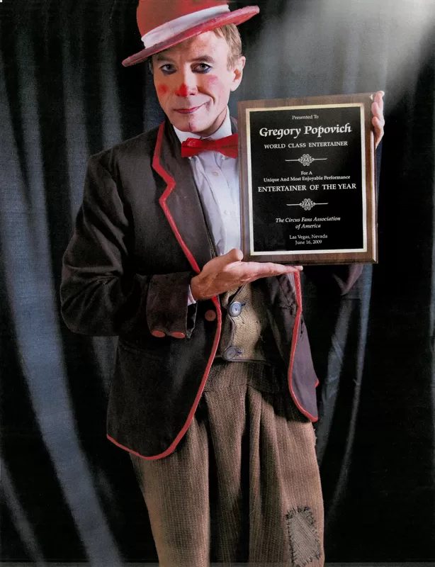 Gregory Popovich holding an award plaque