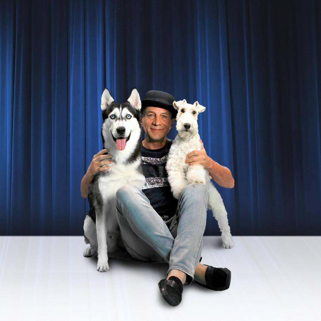 Gregory Popovich sitting between two rescued huskies in the studio